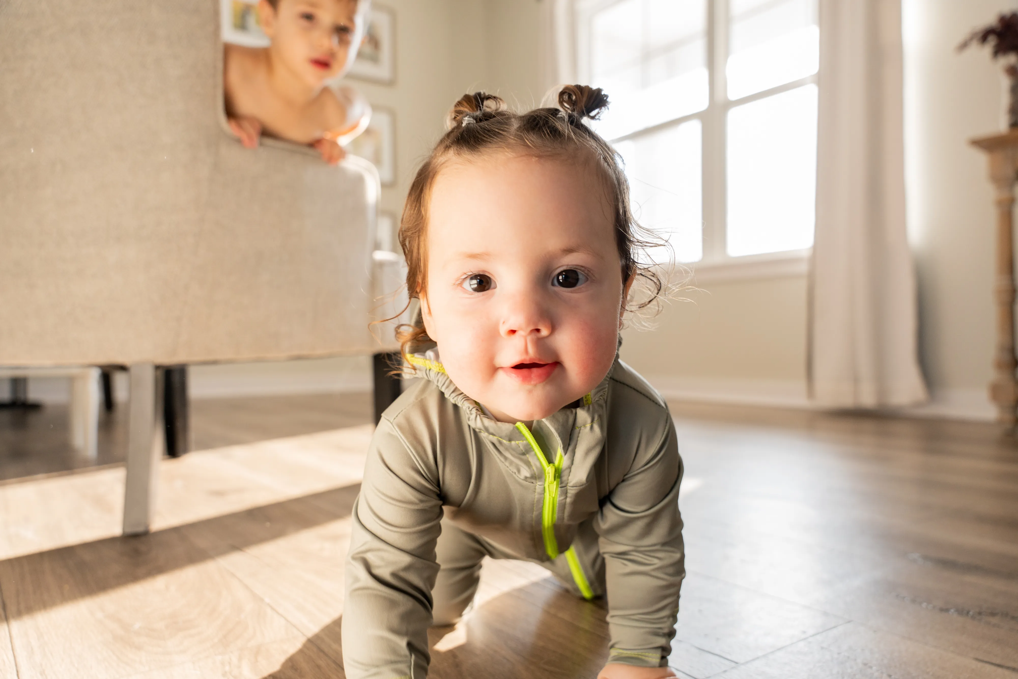 Baby crawling indoors in the independently tested sage green TrailTog UPF 50+ sun suit